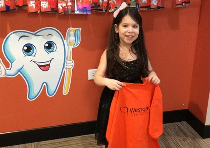 Little girl holding t-shirt for cavity free prize
