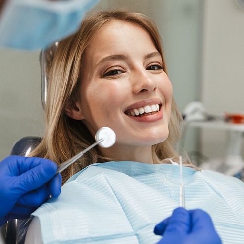 Young woman smiling in dental chair during consultation