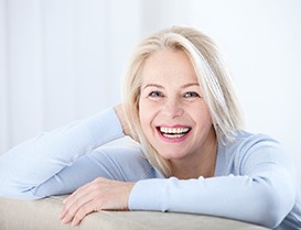 Woman smiling while sitting with white background