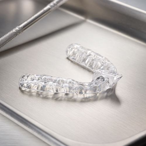 Clear mouthguard for sleep disorders on metal tray