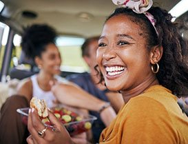 Closeup of woman smiling while eating lunch in car