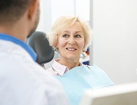 Older woman smiling while sitting in the dental chair