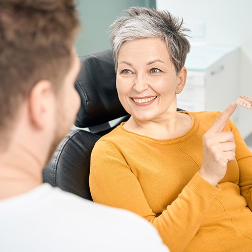 Female patient pointing to mouth mold