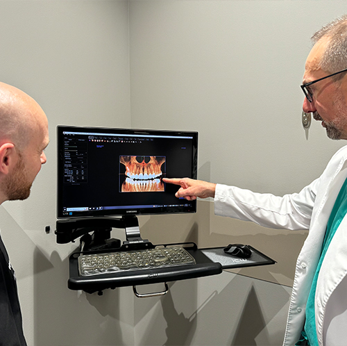 Two dentists looking at digital models of teeth