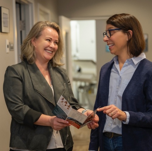 Dental team member showing a pamphlet to a patient