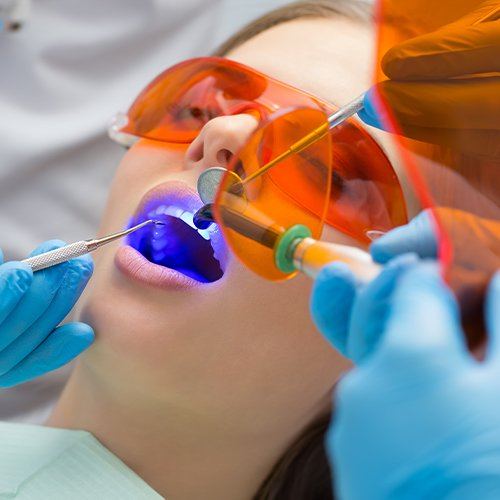 Woman having dental bonding applied to her tooth