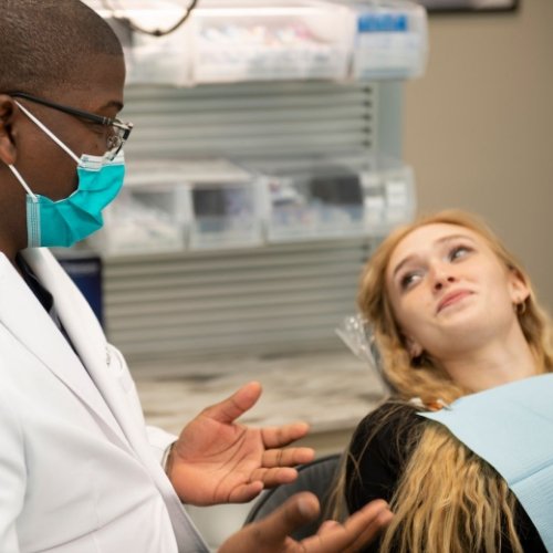 Woman in dental chair listening to her dentist