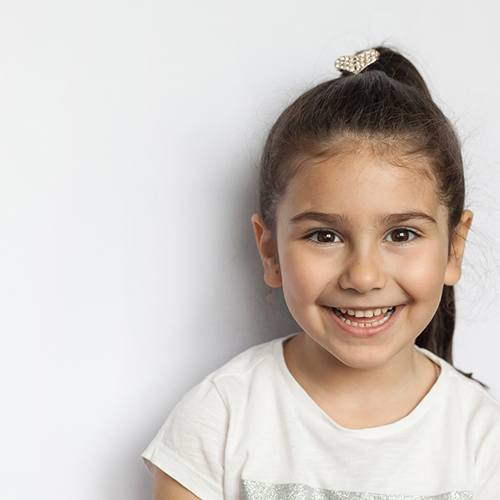 Smiling young girl with brown hair in ponytail