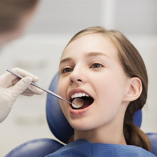 Dentist checking child's tooth colored filling