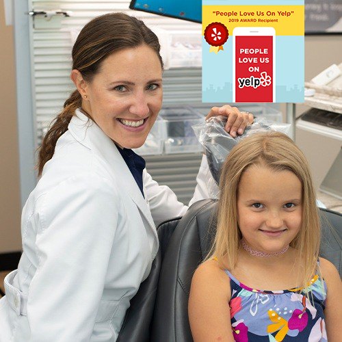 Dentist and young patient smiling together