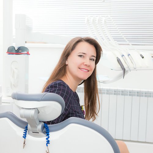 Woman in dental chair smiling with dental crowns in Arlington Heights 
