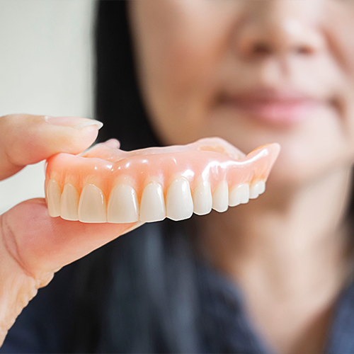 Dental team member holding a denture