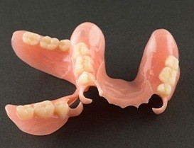Two partial dentures against black background