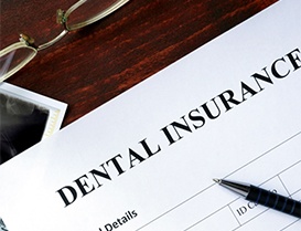 Dental insurance paper with glasses and pen on desk