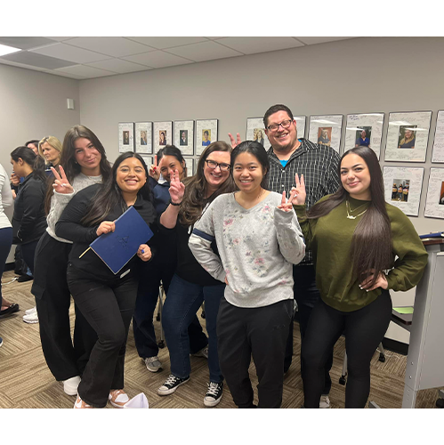 Dental team members smiling and giving peace signs