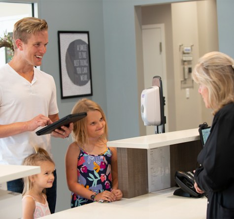 Family talking to team member at front desk