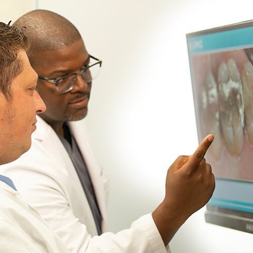 Dentists looking at images of smile before tooth extraction