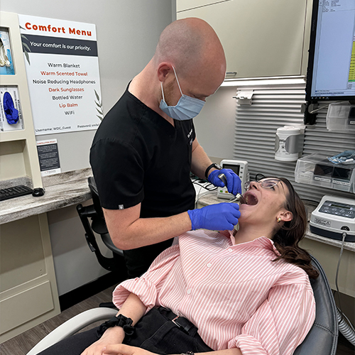 Man in polo shirt smiling with thumb up while sitting in dental chair