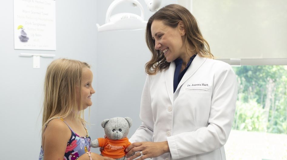 Doctor Hart smiling with a young dental patient