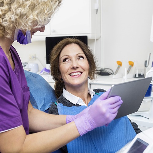dental team member showing a patient a tablet
