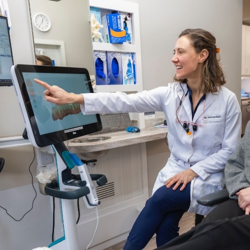 Dentist showing a patient a monitor with digital scans of their teeth
