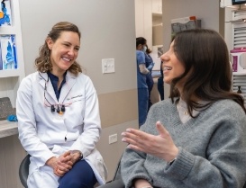 Woman in gray sweater talking to her dentist