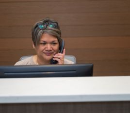 Dental team member sitting at desk and talking on phone