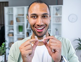 Person using toothbrush to clear aligners