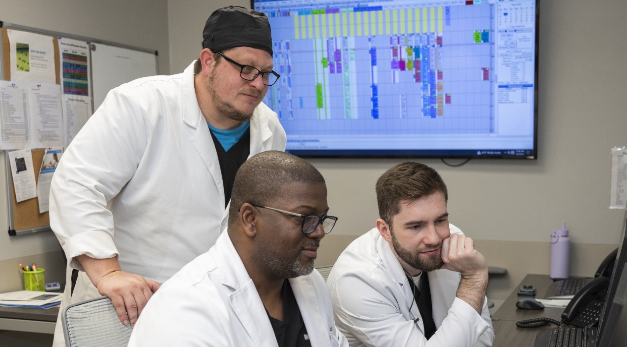 Three dentists looking at computer screen