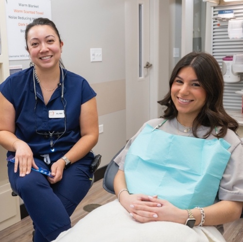 Man smiling in dental chair while wearing collared shirt