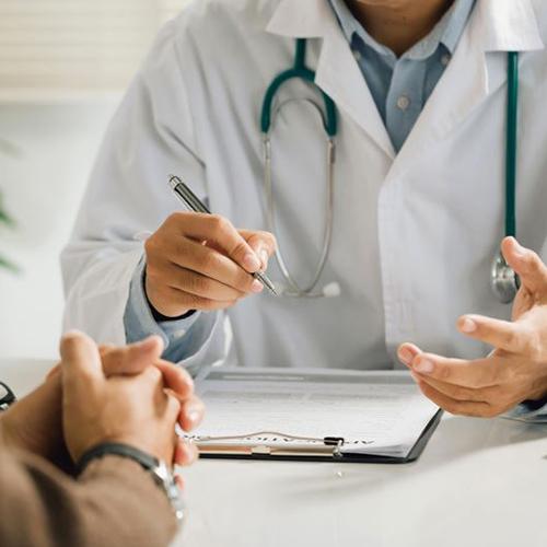 Patient and doctor sitting at desk curing consultation