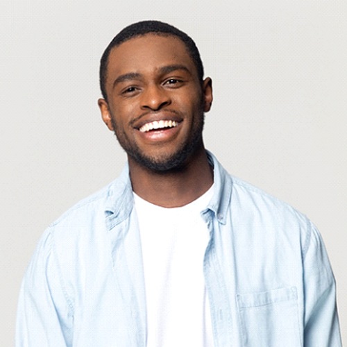 Man with white t shirt and collared shirt smiling