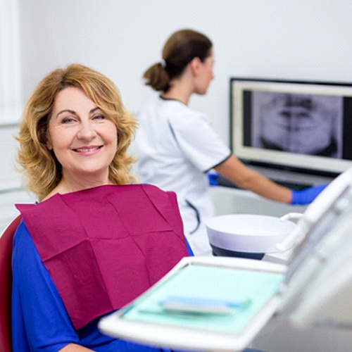 Woman smiling while sitting in dental chair