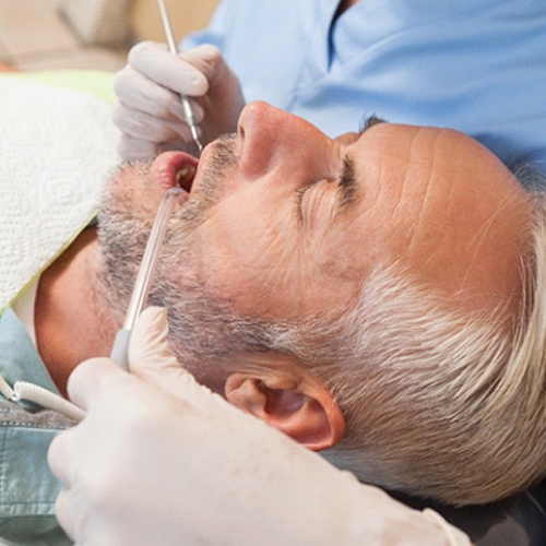 Middle-aged man with eyes closed during his dental appointment