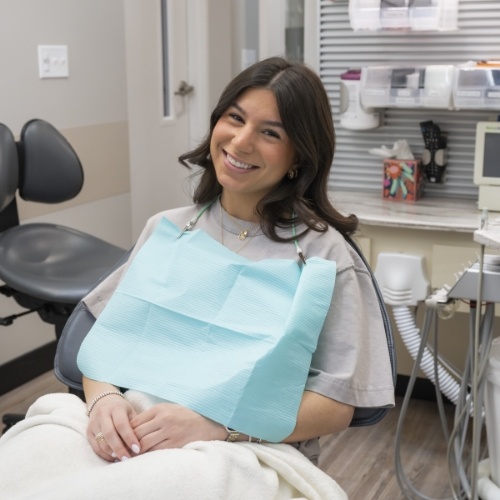 Woman in dental chair smiling after gum disease treatment in Arlington Heights