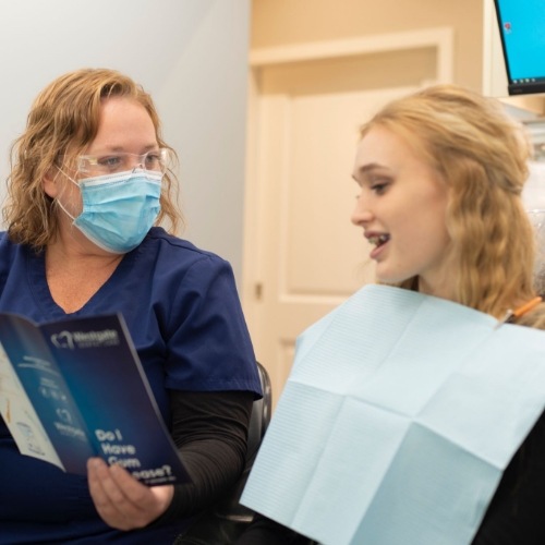 Dental team member showing a pamphlet to a patient