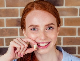 young woman holding an extracted tooth