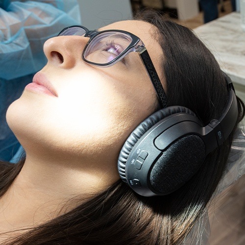 Woman wearing headphones in dental chair