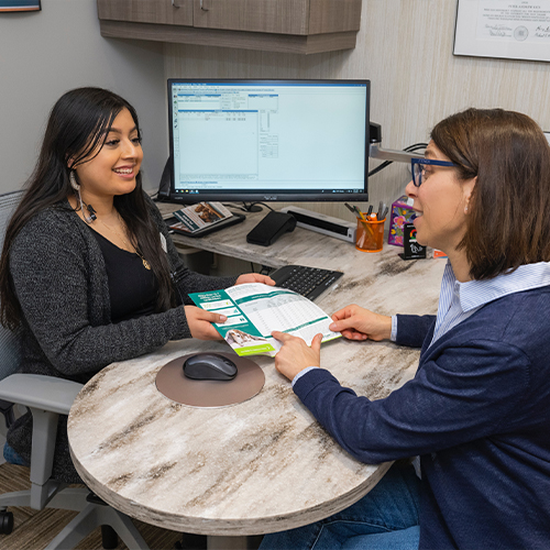 Dental team member handing a pamphlet to a patient