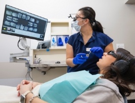 Dental team member showing a patient x rays of their teeth