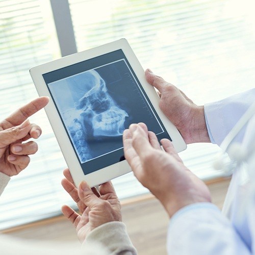 Dentists looking at x ray of skull and jaw