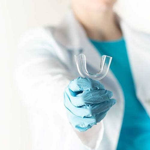 Dentist holding clear occlusal splint tray