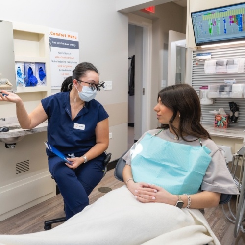 Dentist showing a clipboard to a patient