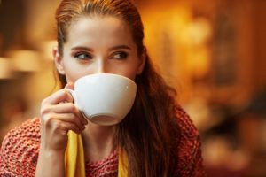 A woman drinking a cup of coffee.