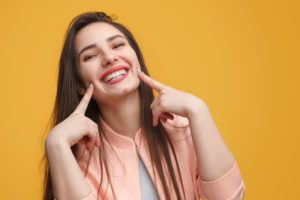 Woman smiling pointing at her teeth