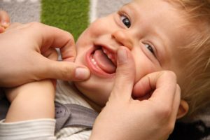 Boy smiling in chair during first children’s dental visit