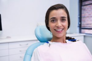 Woman smiling in dental chair for gum disease treatment