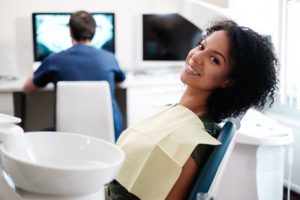 Woman relaxing in dental chair after saving with dental insurance