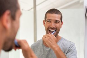 Man brushing his teeth using oral hygiene tips