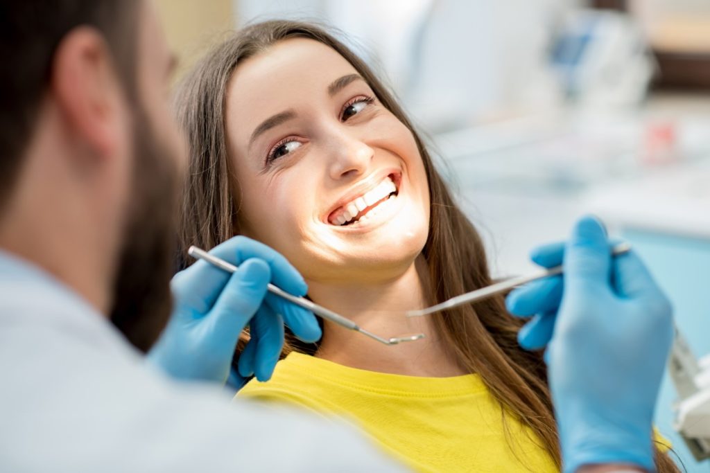 Patient smiling during routine dental checkup and cleaning